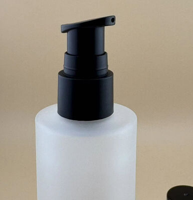 Mat transparante glasfles met zwarte behandelingspomp voor cosmetica
